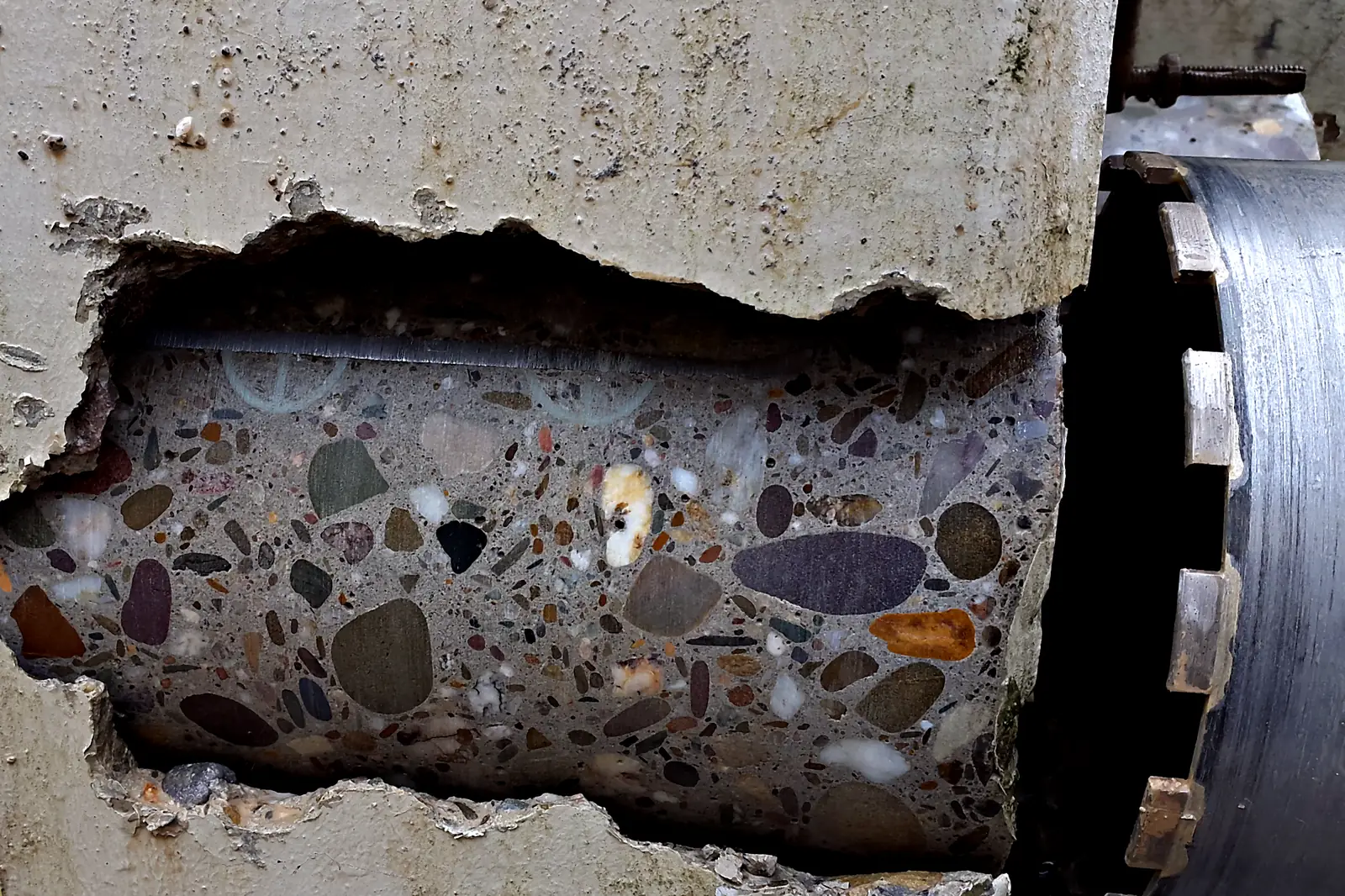 Diamant-Bohrkrone neben einem freigelegten Bohrkern in Stahlbeton